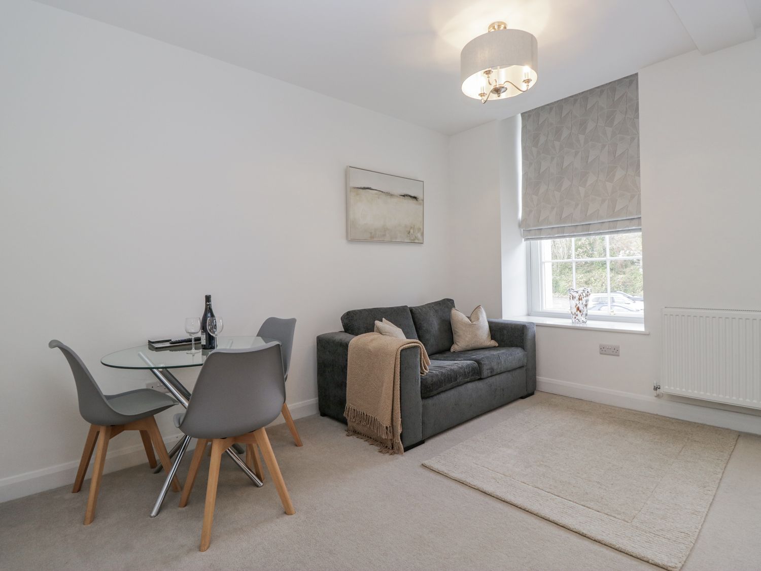 A living room with a dining table and sofa at Derwent in Ulverston