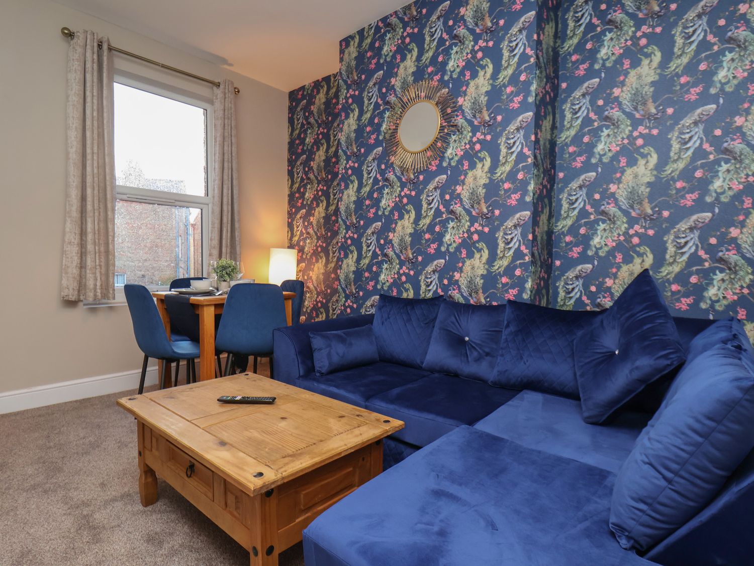 A living room with a blue sofa and wooden coffee table at Apartment 2, Blackburn Heights in Bridlington