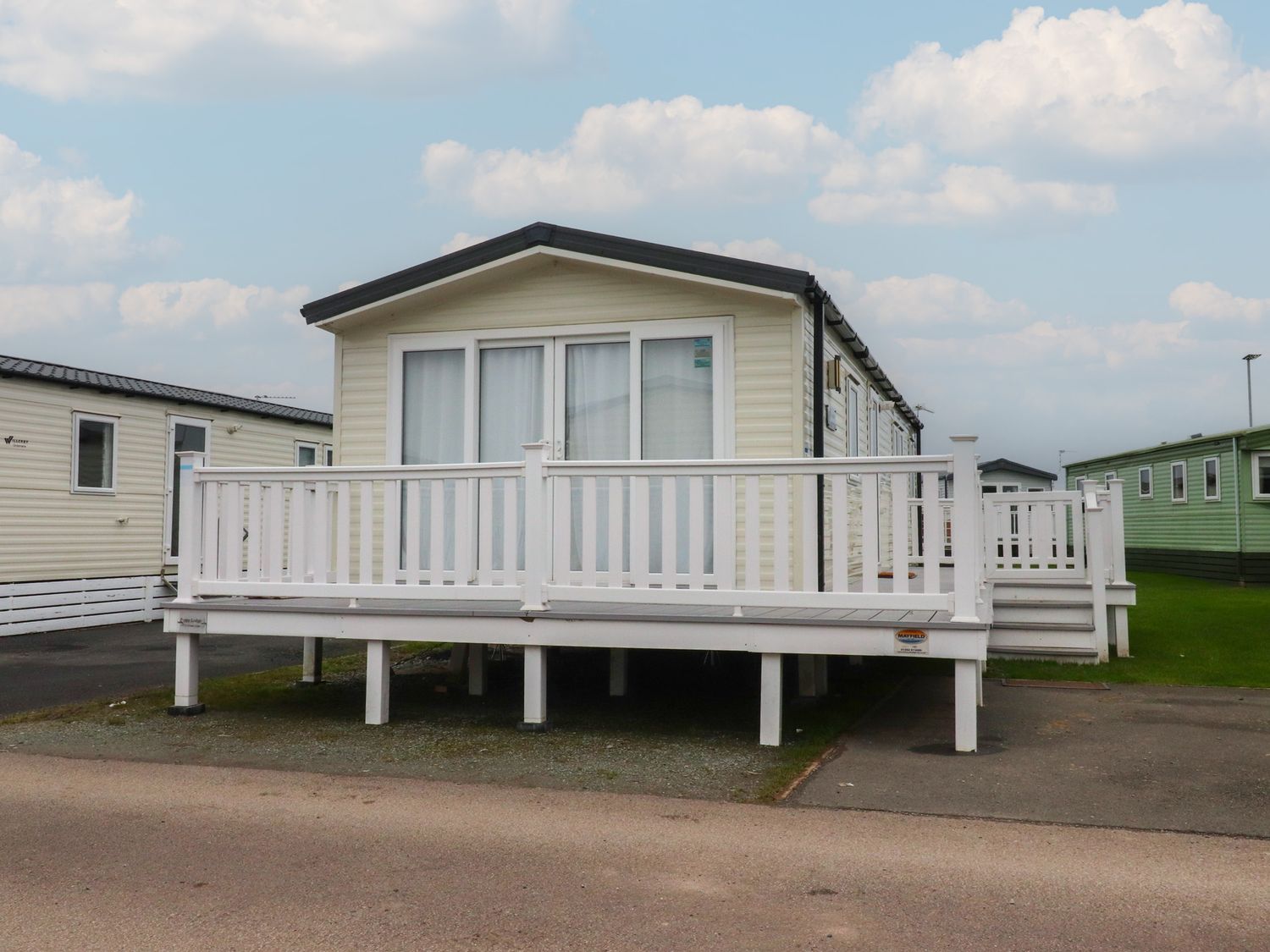 A mobile home with a deck at Poppy Lodge in Heysham