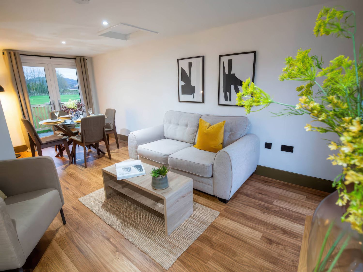 A living room with a sofa and dining area at Fir Cottages in Llanrwst