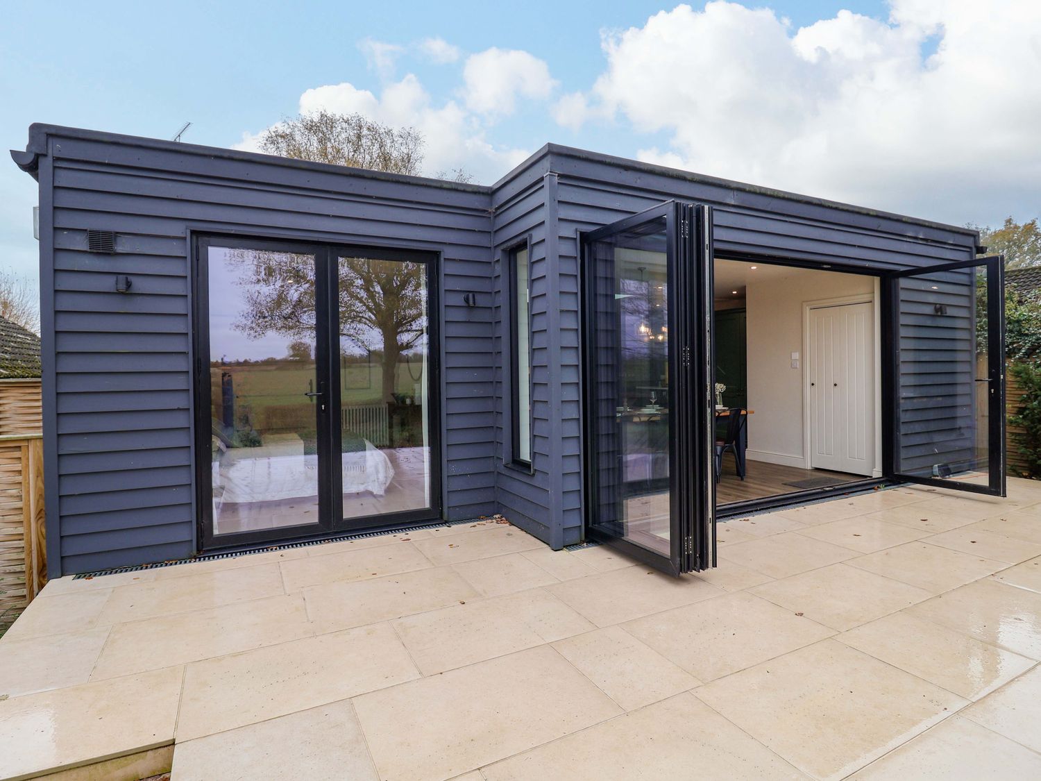 An outdoor space with sliding doors and patio tiles at Fairview in Darsham