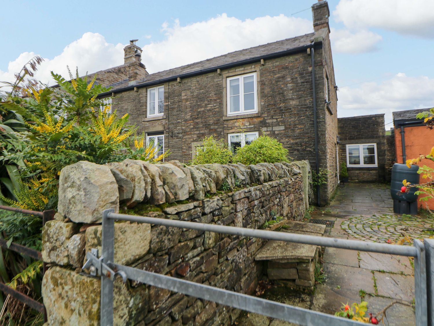 A house with stone walls and a garden at The Farmhouse in High Peak