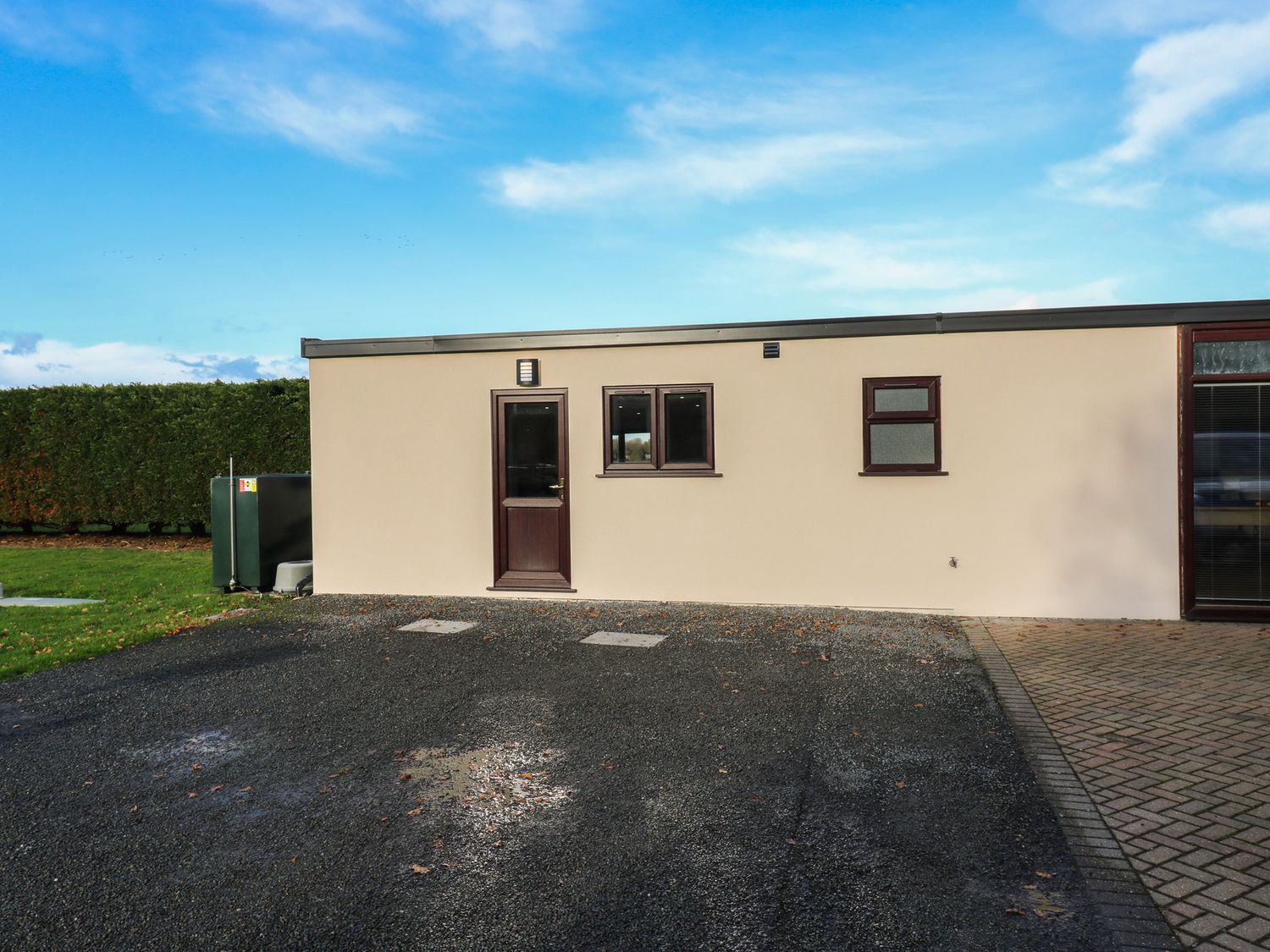 An exterior view of a building with a door and windows at Aloe Lodge in Diss