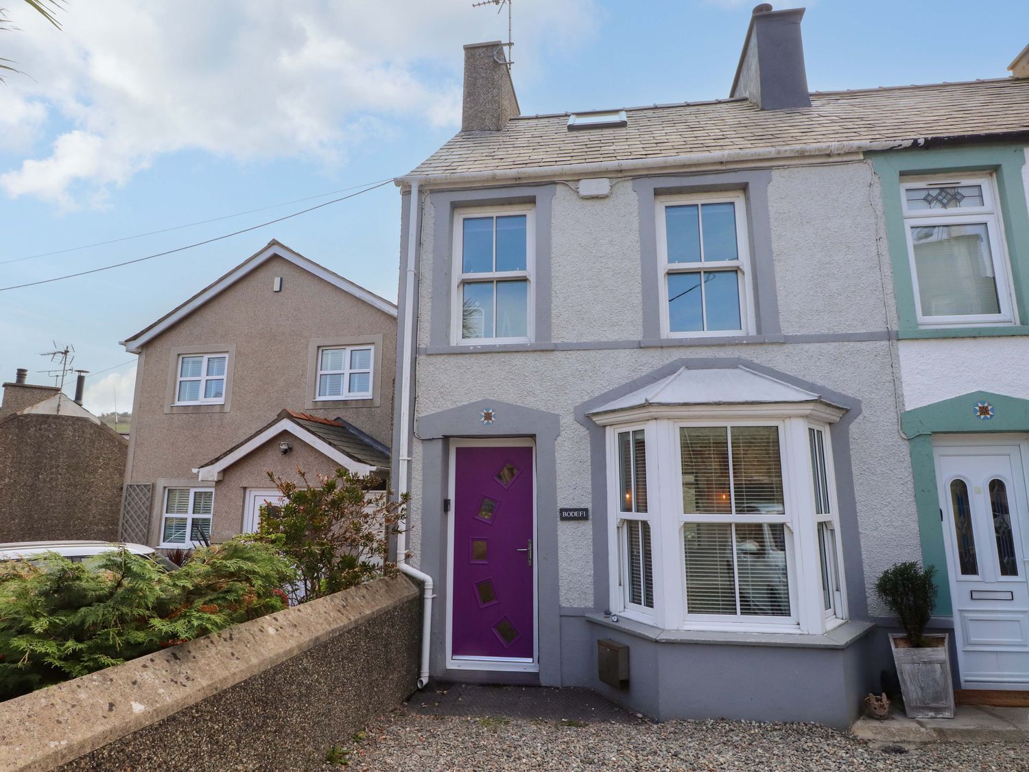 A house exterior with a purple door and windows at Bodefi in Pwllheli