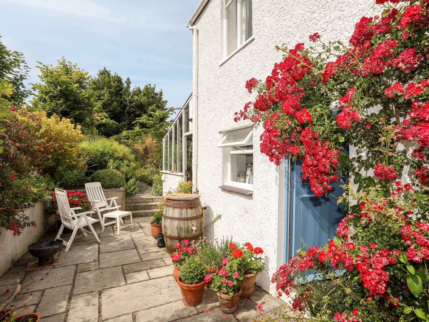 A garden with flowers and chairs at Bryn Tegid in Beaumaris