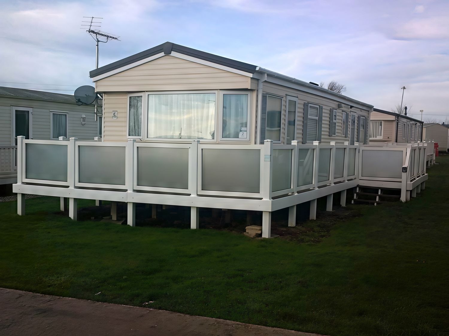 A caravan with decking at Coopers Beach Holiday Park - Holiday Accommodation 3999 Mersea Island