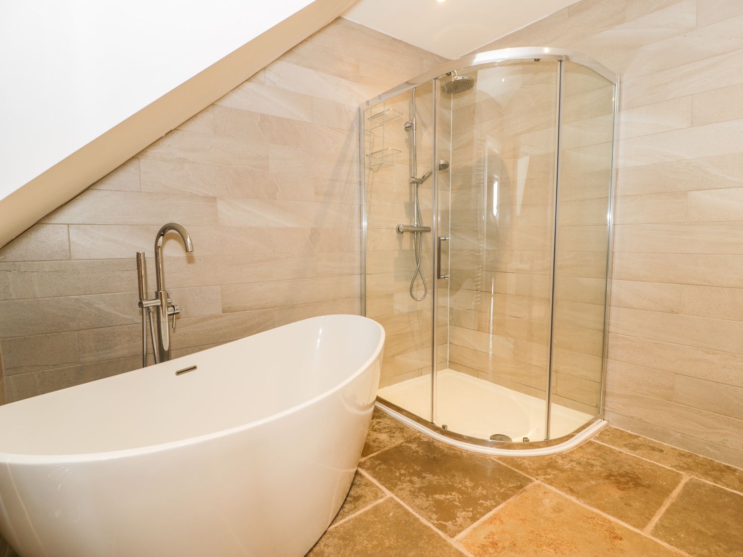 A bathroom with a freestanding bathtub and a glass-enclosed shower at Cae Sam in Pentraeth