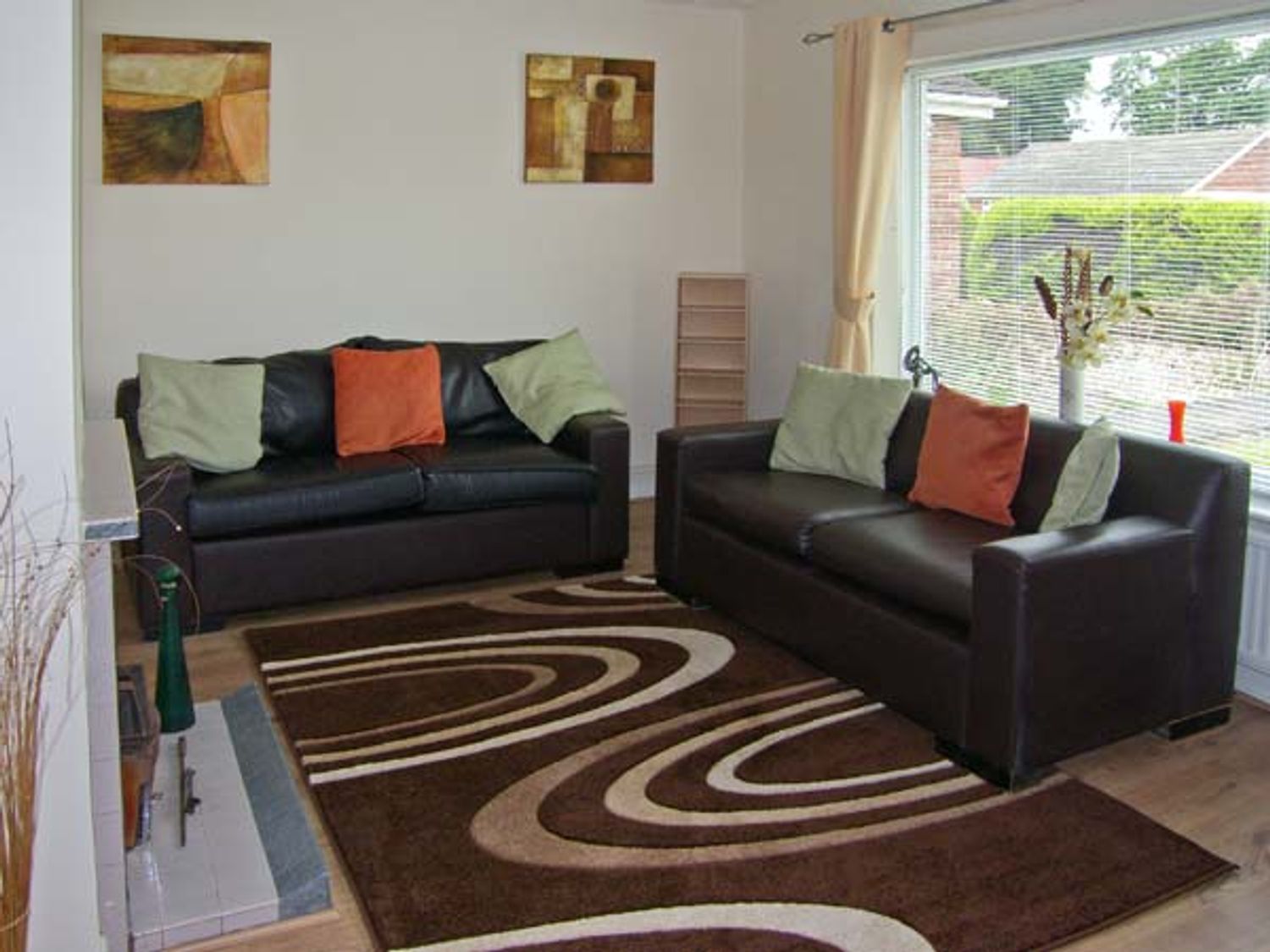 A living room with two sofas and a patterned rug at Sunnyside Cottage in Hogsthorpe near Skegness