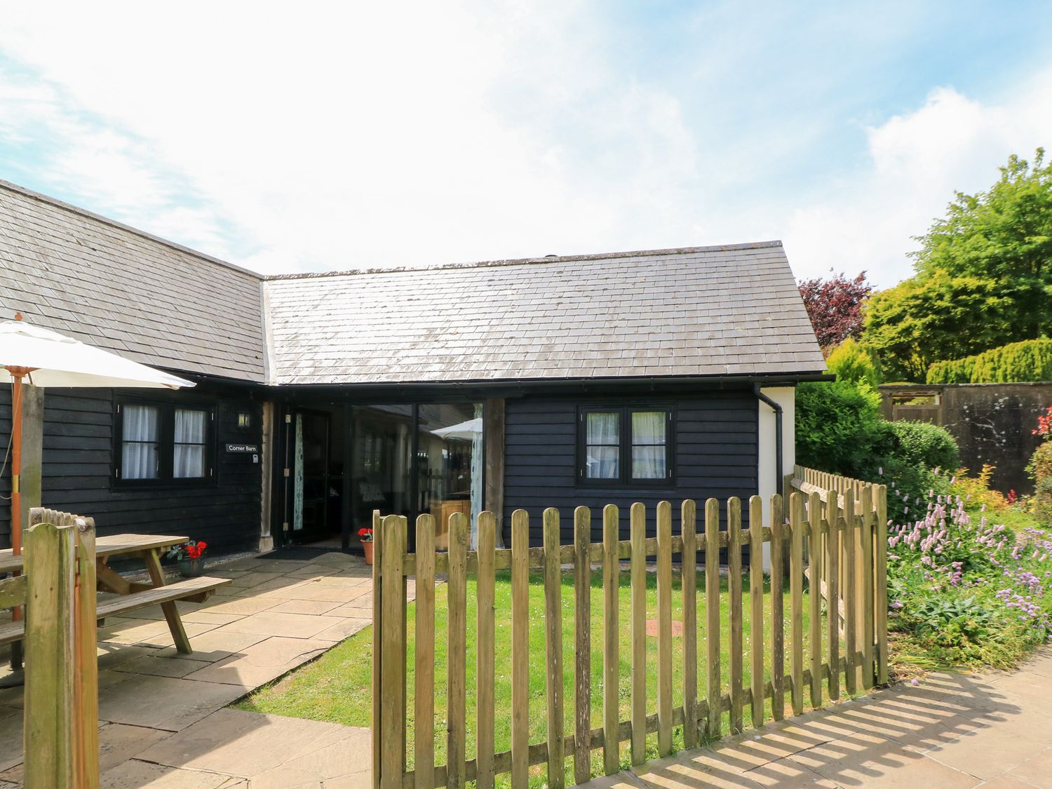 An outdoor area with a table and umbrella at Corner Barn in Winterborne Stickland