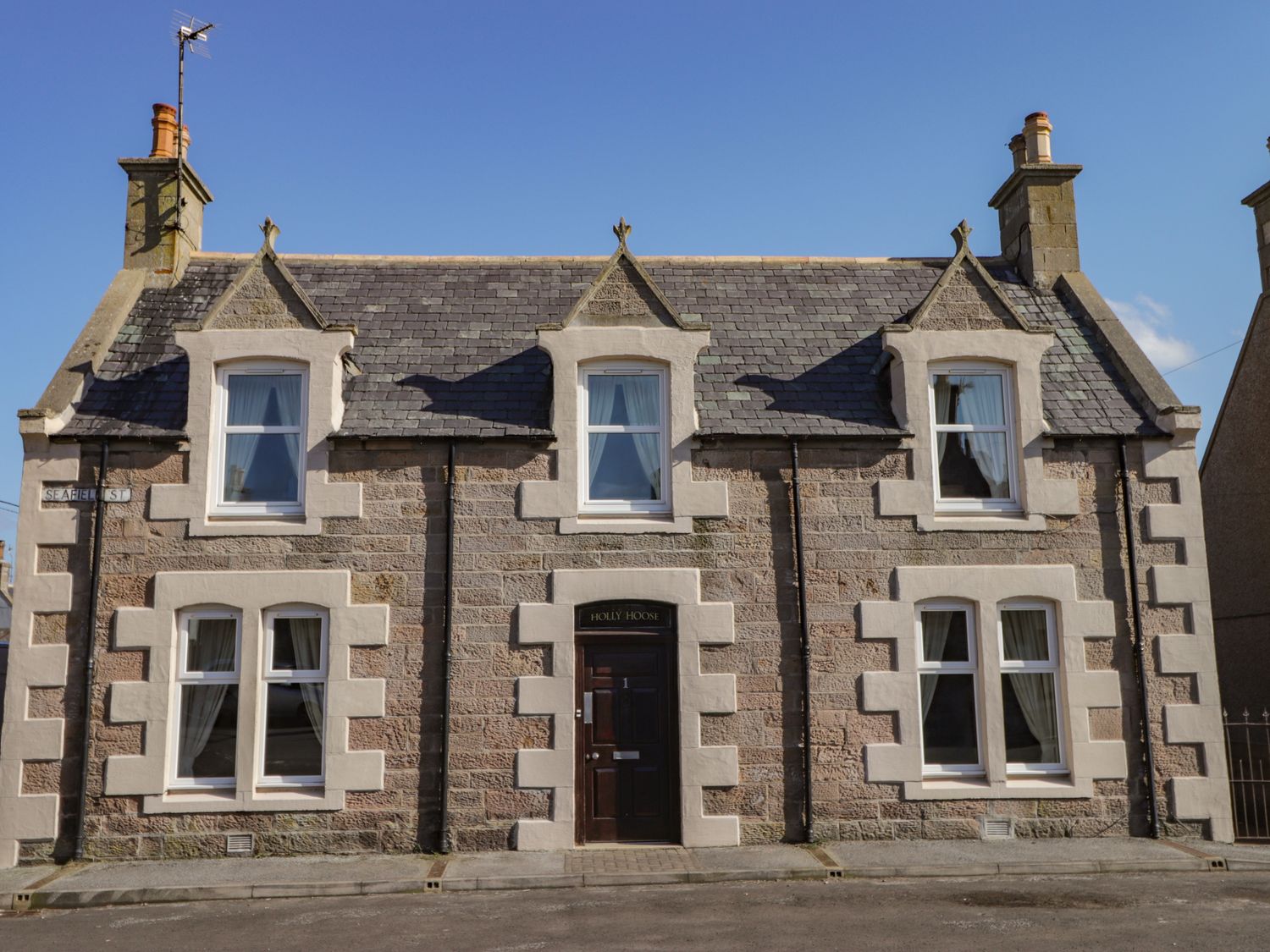 A stone house with six windows a central door and a slate roof at Holly Hoose in Findochty near Buckie