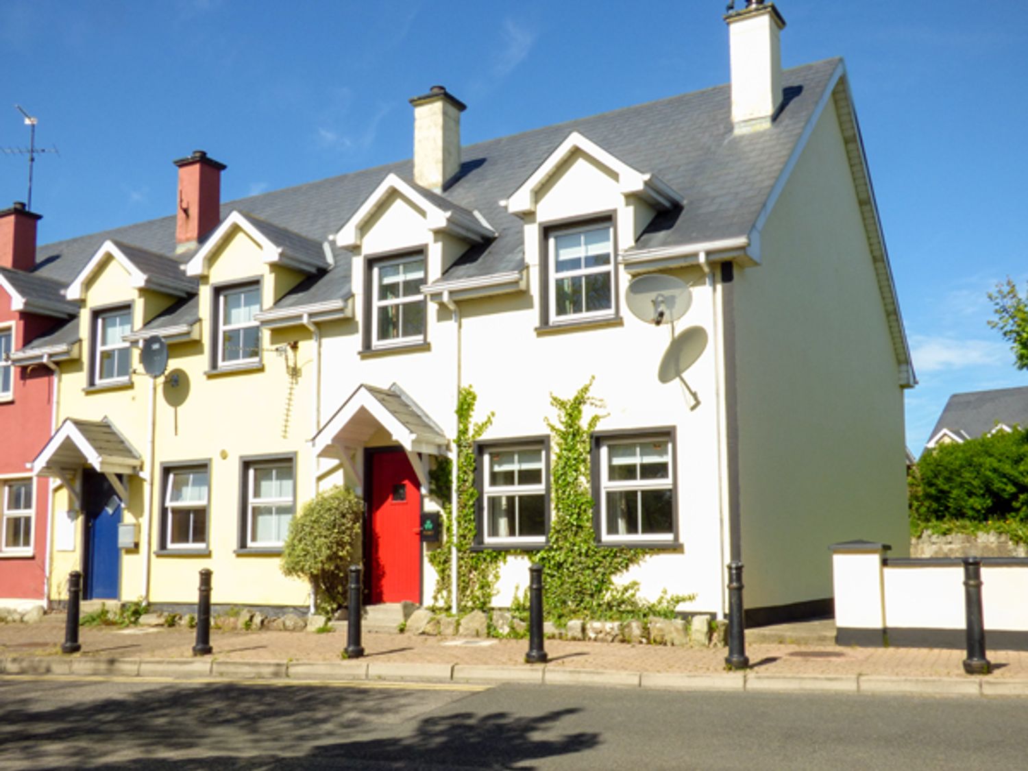 A row of connected houses with different colored doors along a street at No 17 Mountain Dale in Tullaghan County Leitrim