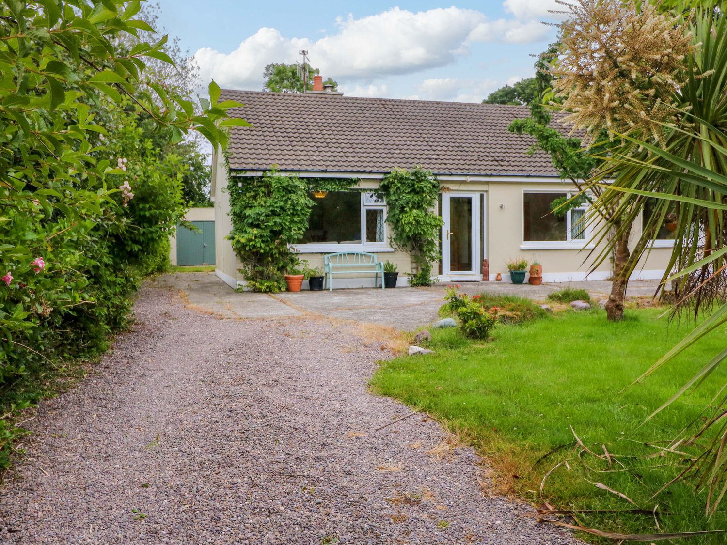 A house with a gravel path and green plants at Rowantree, Beaufort, County Kerry
