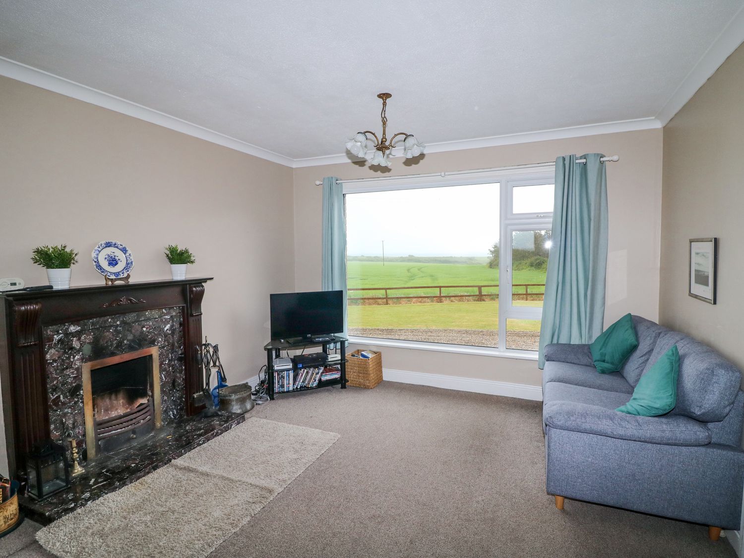 A living room with a fireplace and sofa at Findale, Carne near Rosslare, County Wexford
