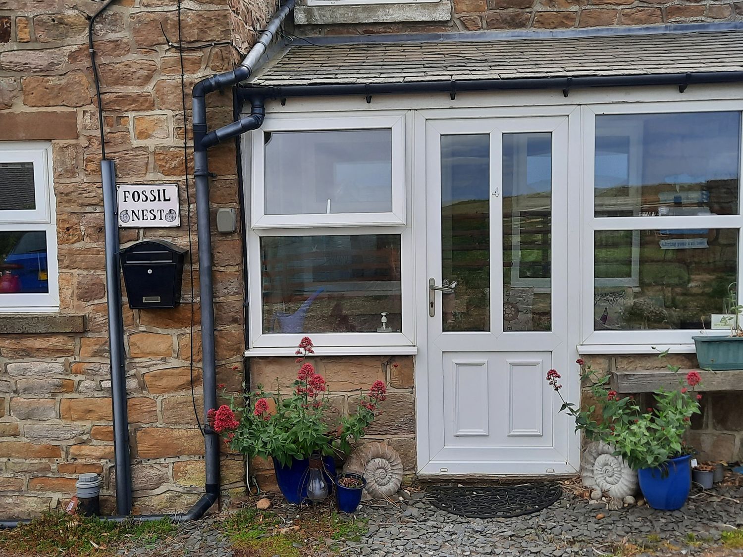 An entrance with a door and plants at Fossil Nest