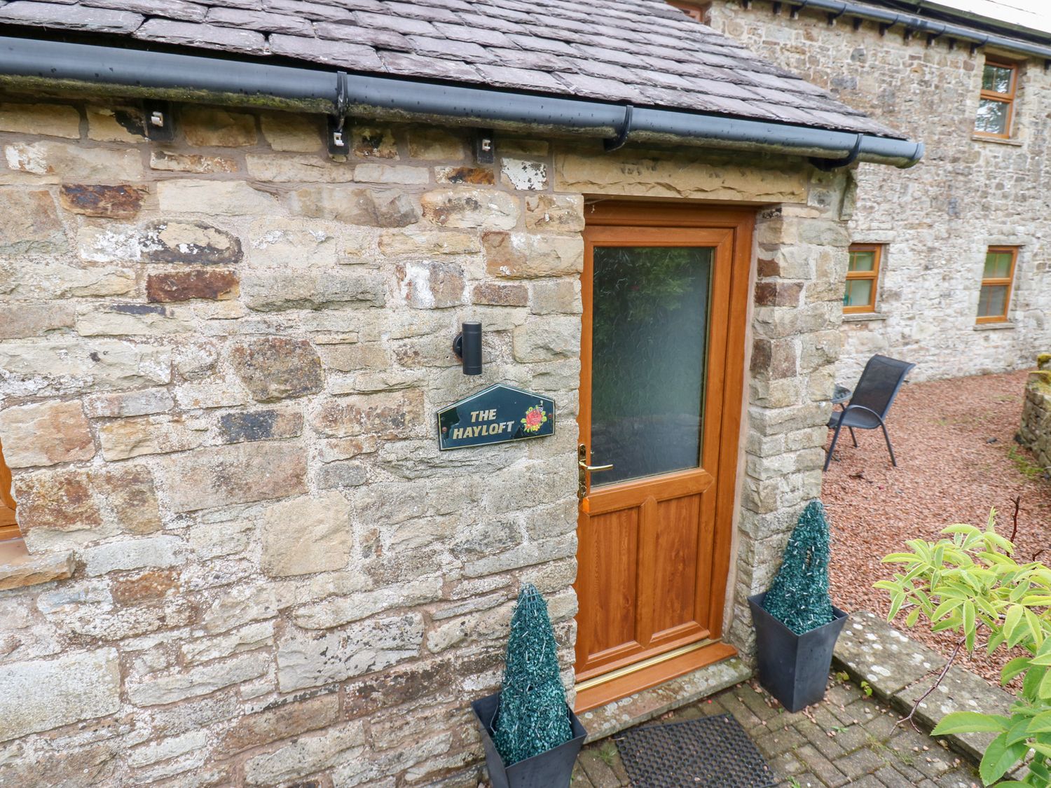 An entrance with a door and sign at The Hayloft in Alston