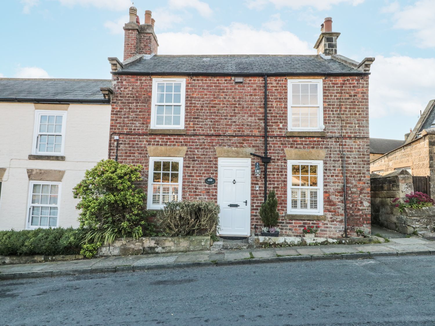 A brick house with windows and a door at Croft View in Fylingthorpe near Robin Hood's Bay