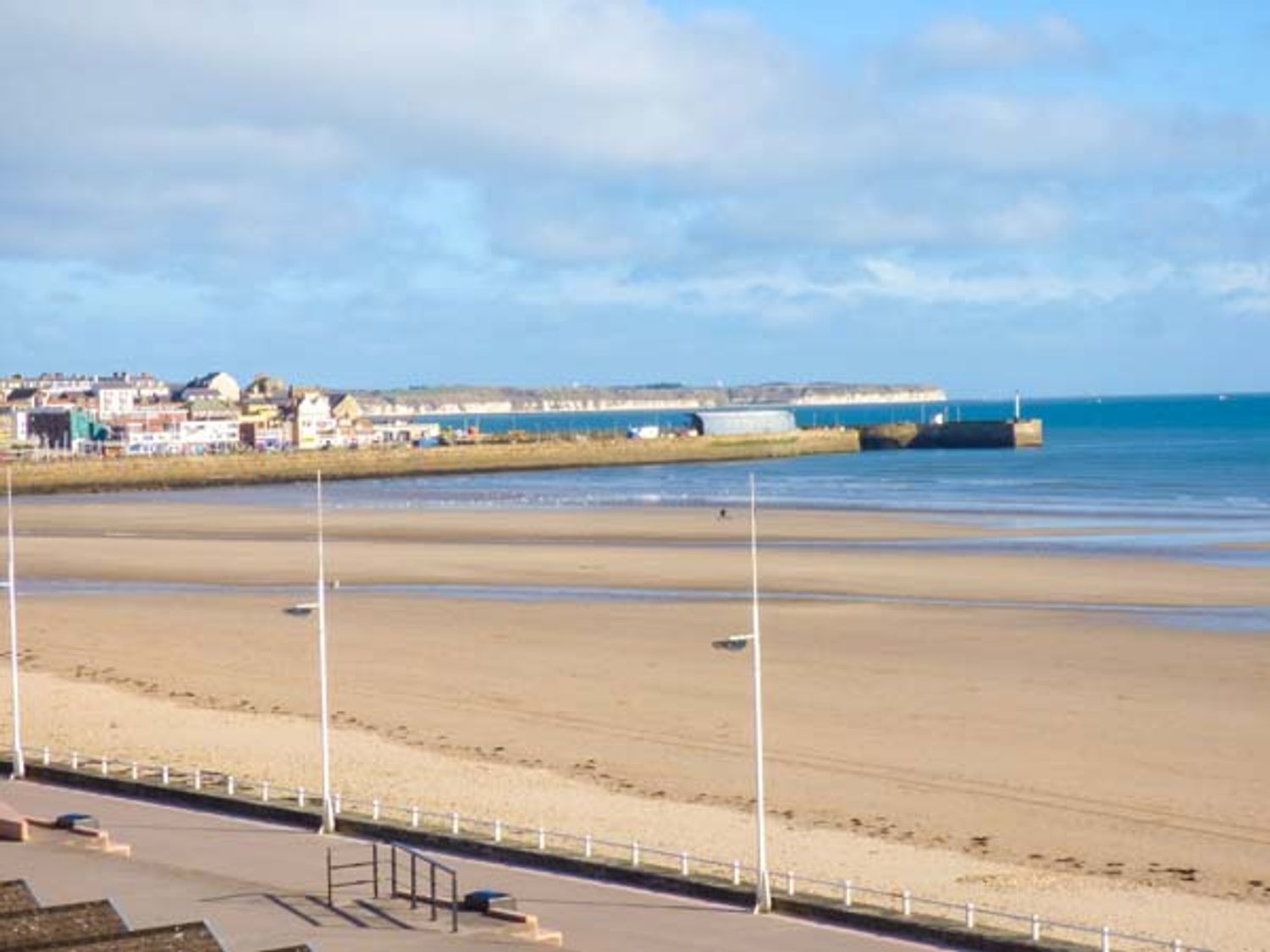 A sandy beach with a promenade and street lamps by the sea at Flat 3 in Bridlington