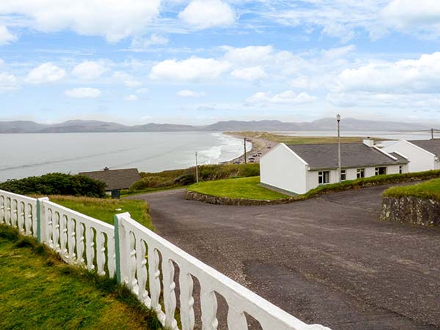A coastal view with white cottages and a road near a beach at Rossbeigh Beach Cottage No 6 Rossbeigh near Glenbeigh County Kerry