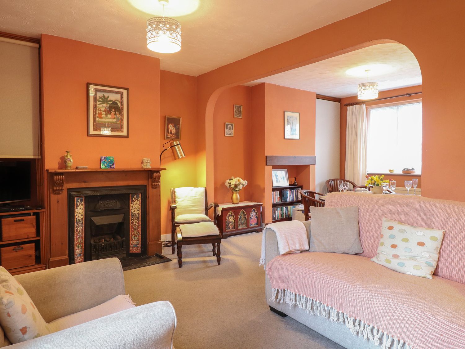 A living room with a fireplace two armchairs a sofa and a dining area at Sea Pearl in Pakefield near Lowestoft