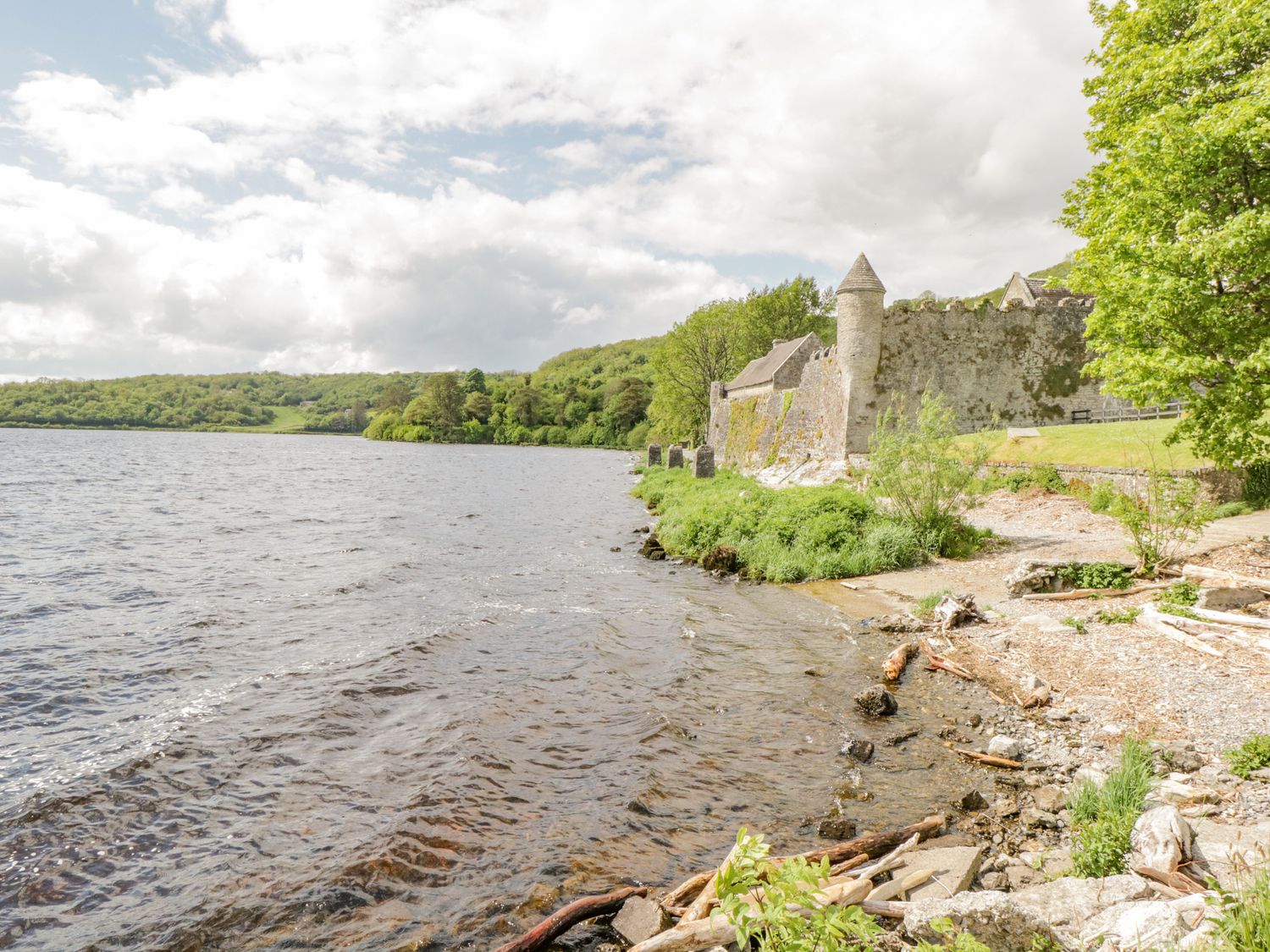A lakeside view with a stone castle wall and trees at 2 Castle Cove in Dromahair County Leitrim