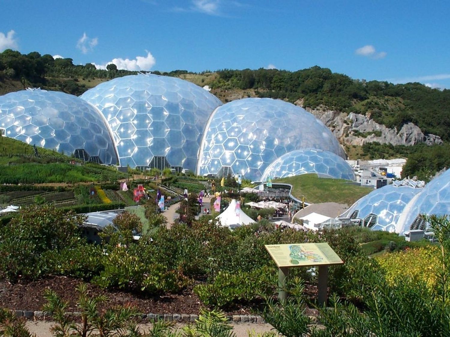Outdoor view of large geodesic domes with plants and walkways in front at Higher Kernick Stable Helland near Blisland