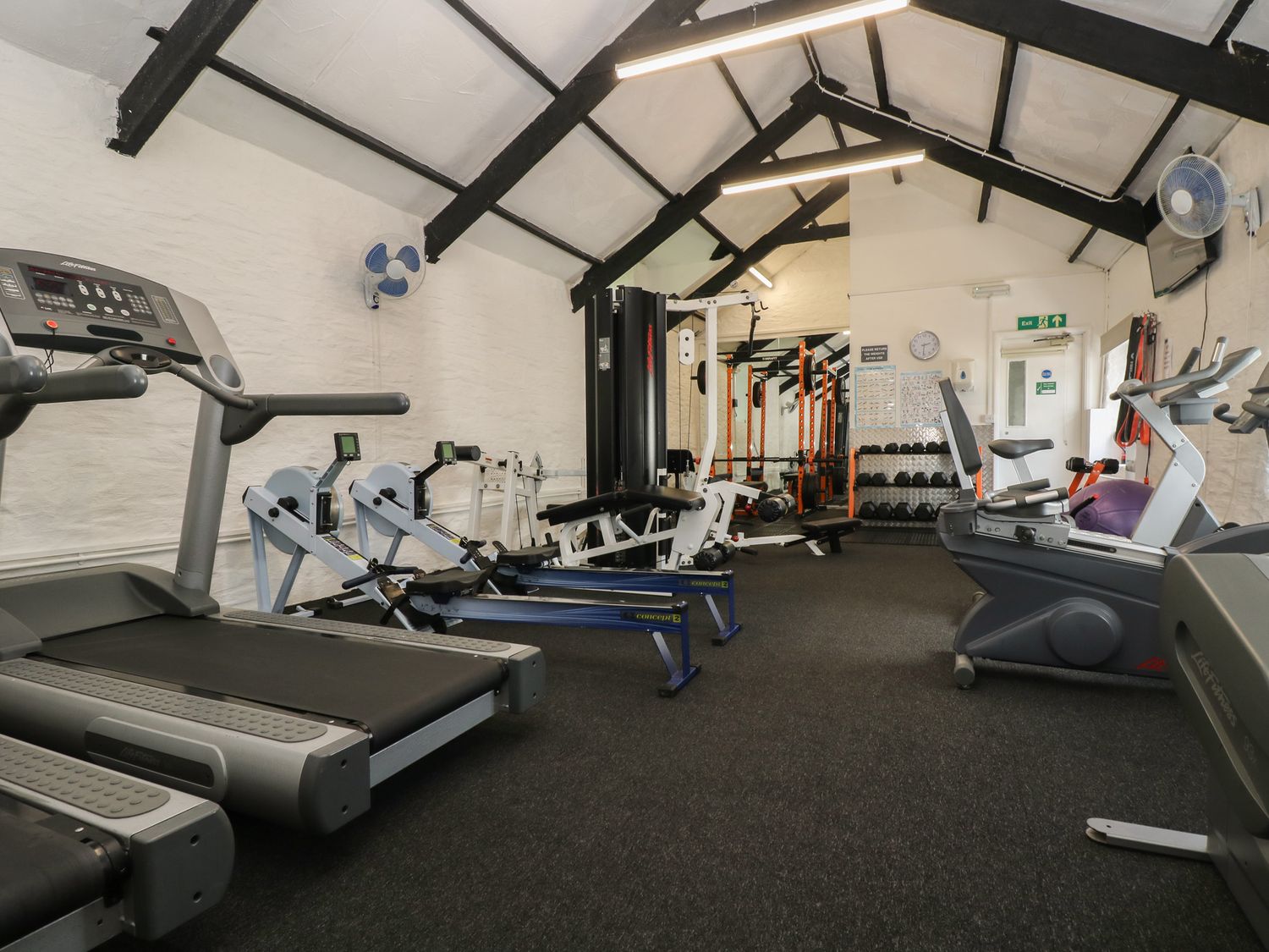 An exercise room with treadmills rowing machines weights and stationary bikes at Valley Lodge 61 in Callington