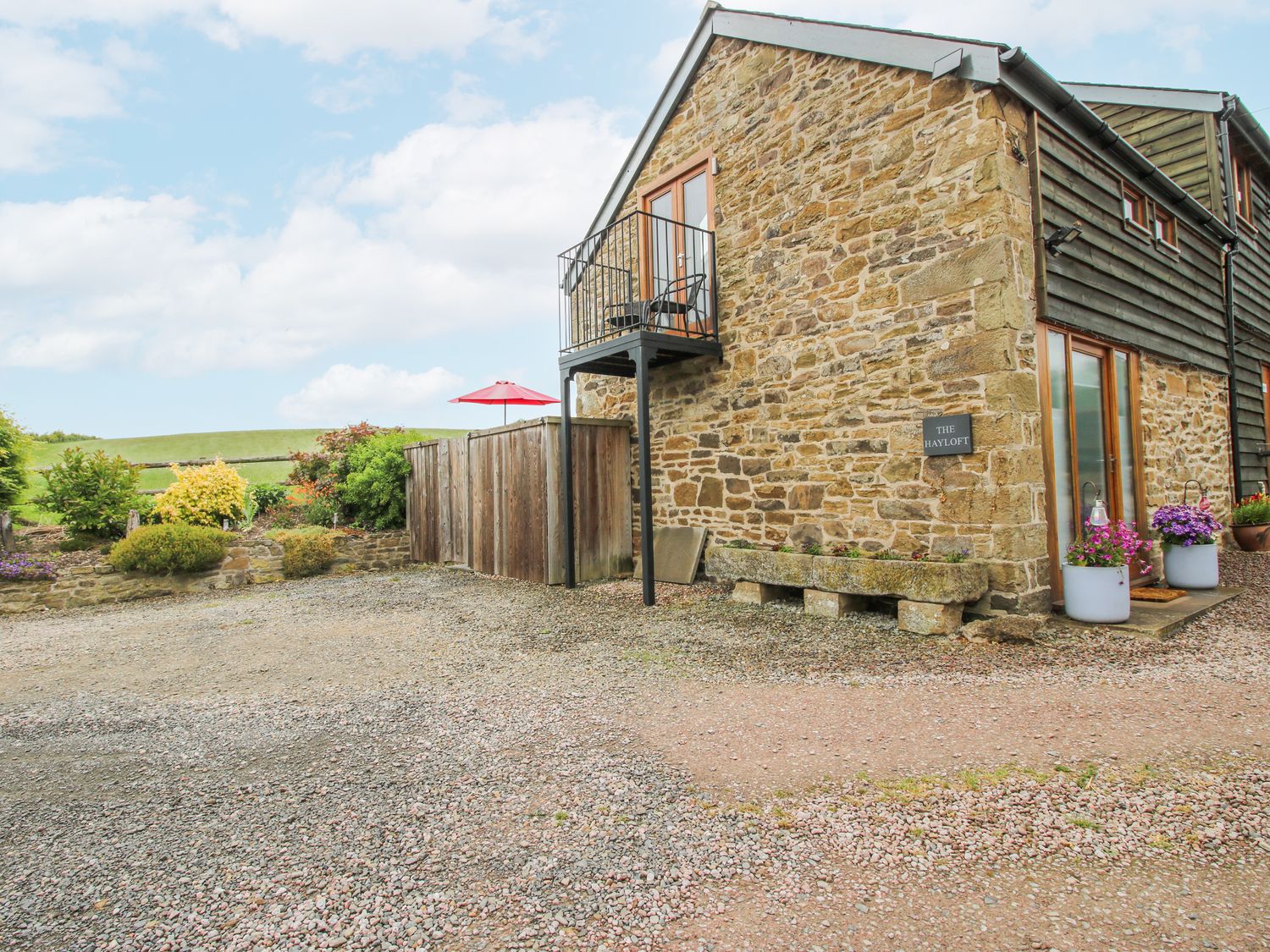 A cottage with a gravel driveway at The Hay Loft in Craven Arms