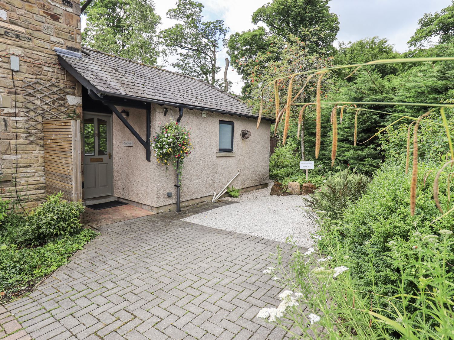 An entrance with a gravel path and a flower pot at Doe Foot Cottage Ingleton