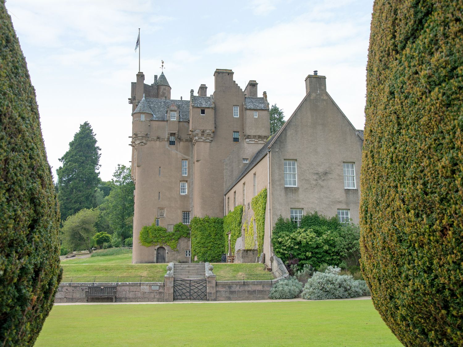 A historic castle building with ivy on the walls surrounded by trimmed bushes and a grass lawn at Nef-Stedi in Inverurie