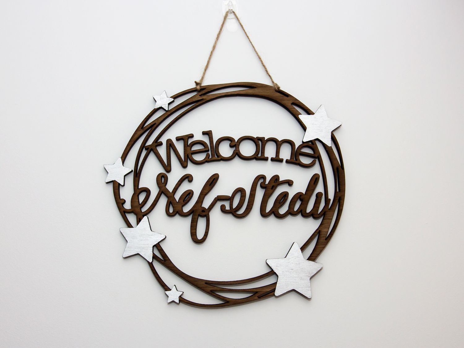 A wooden wall hanging with the words welcome self-stedi and white stars at Nef-Stedi in Inverurie