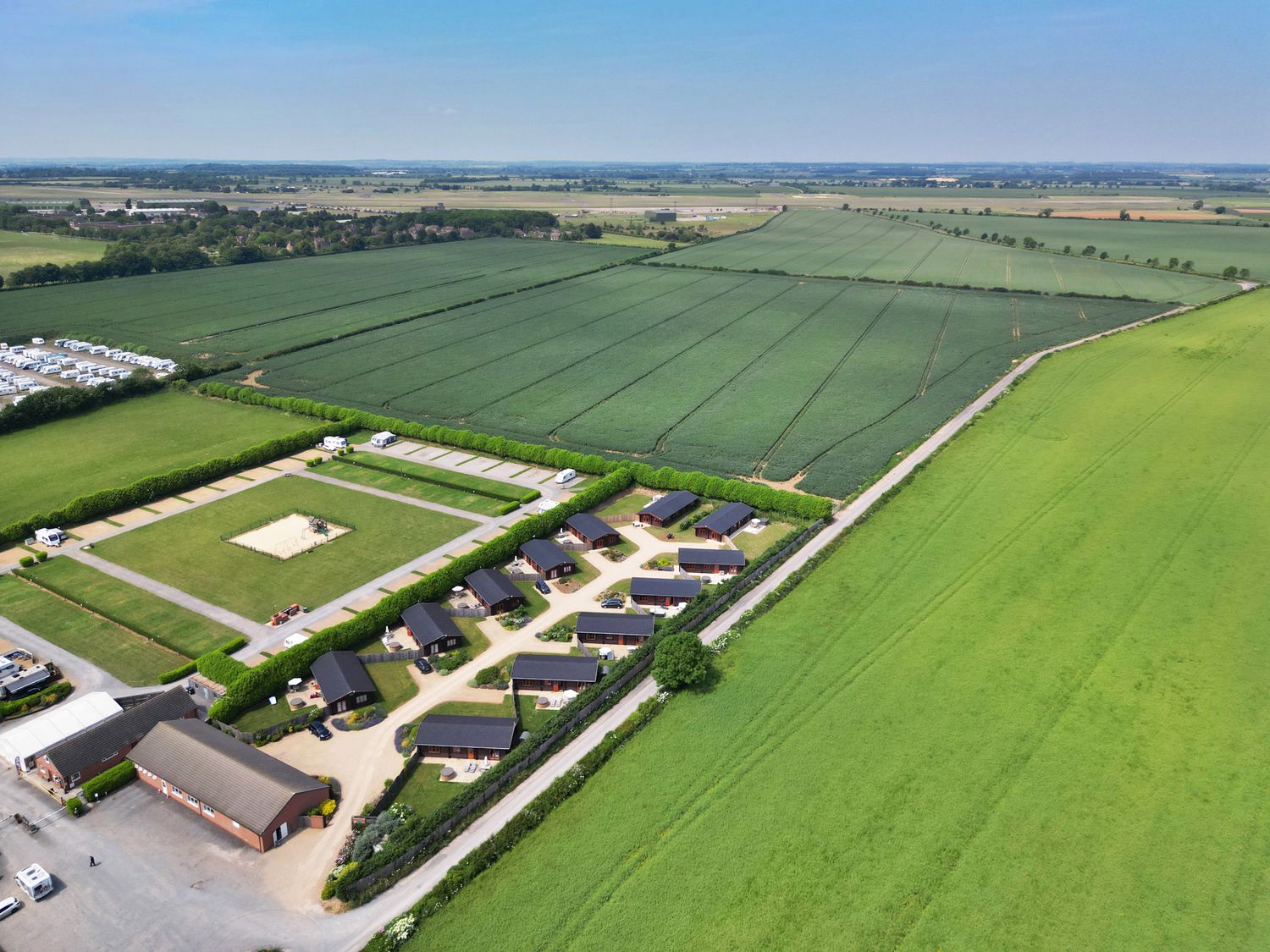 An aerial view of a holiday park with cabins green fields and a playground at Ash Lodge in Greetham Rutland