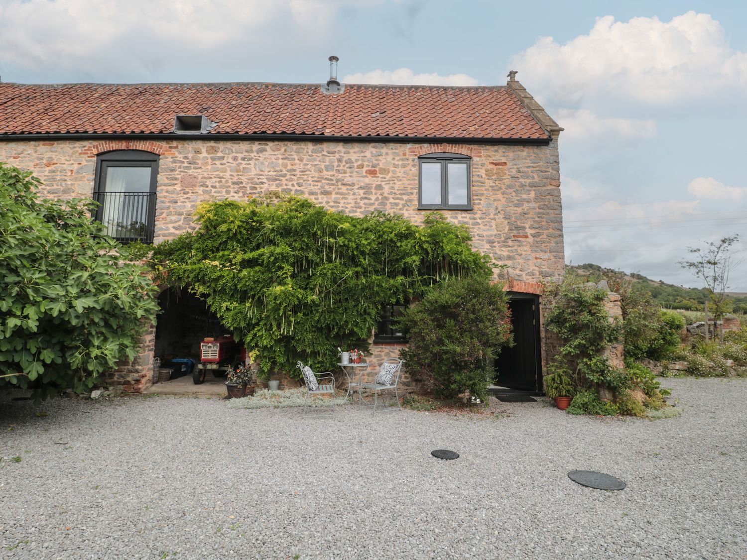 An outdoor area with plants and chairs at The Barn in Compton Bishop, near Cheddar