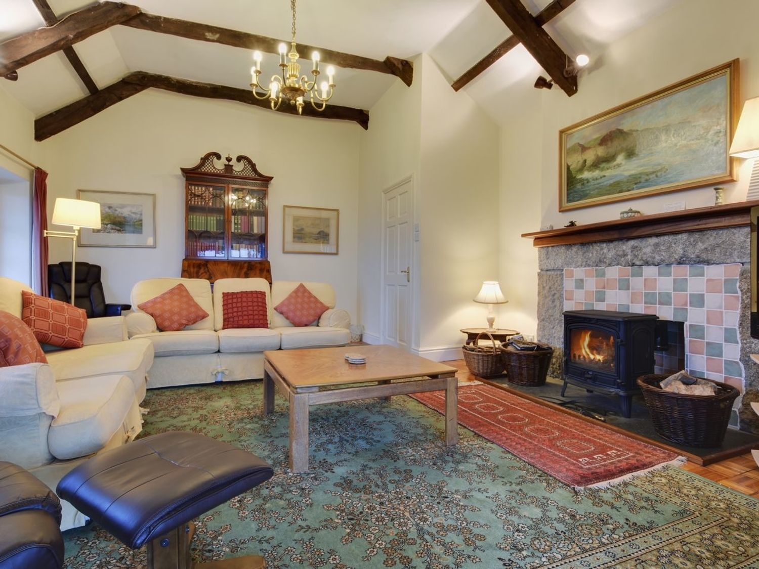 A living room with sofas coffee table fireplace and wooden beams at Higher Tumrose in Blisland