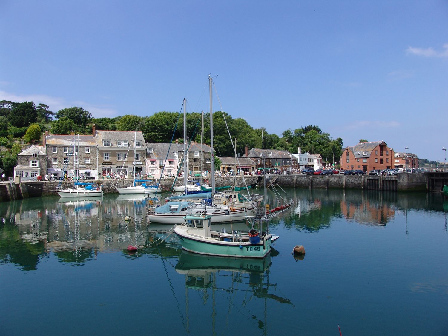 A harbor with boats docked in the water and buildings along the shoreline at Mount Pleasant in Padstow