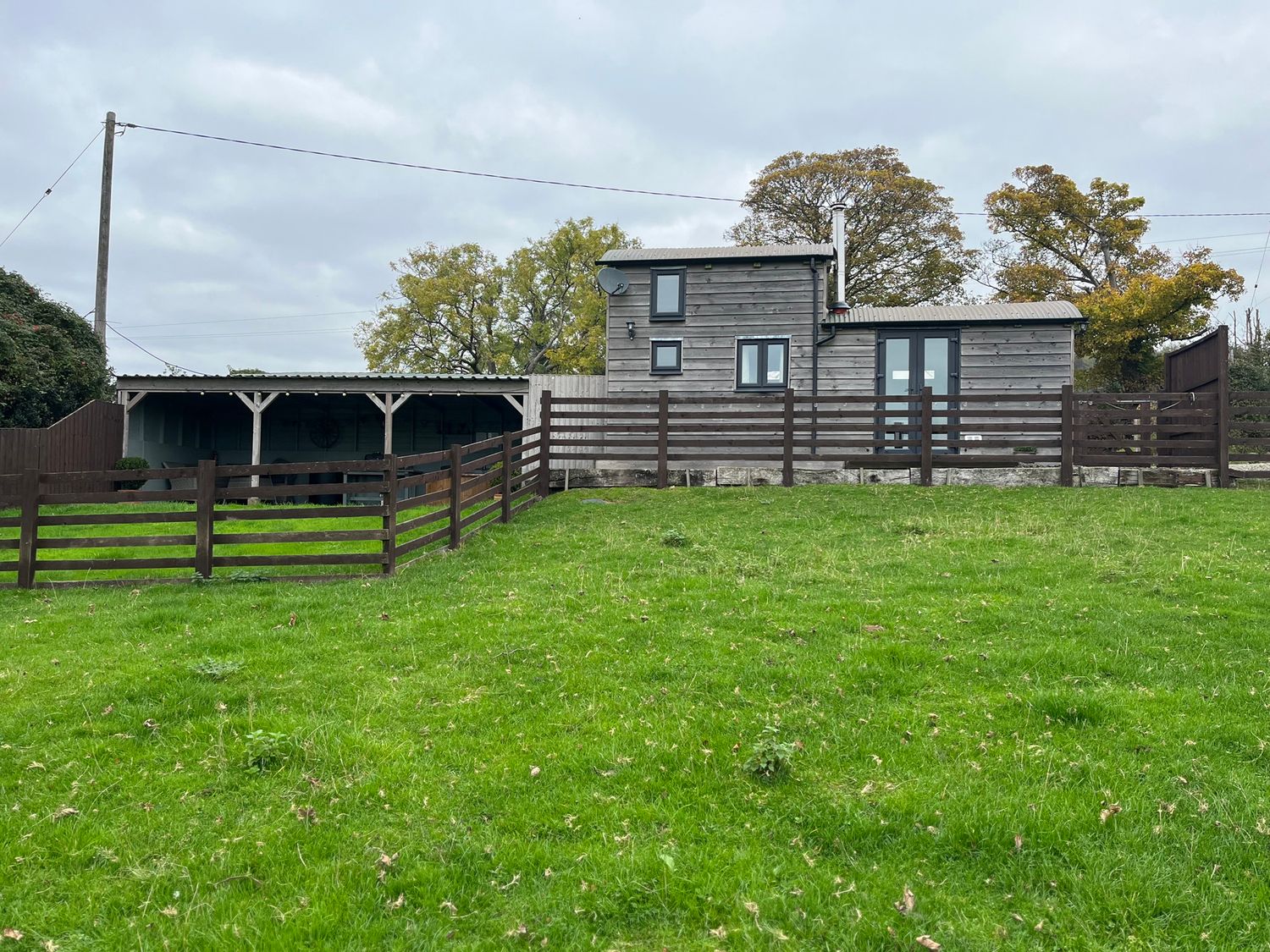 A house with a fence and grass at Shepherds Cabin at Titterstone Clee Hill