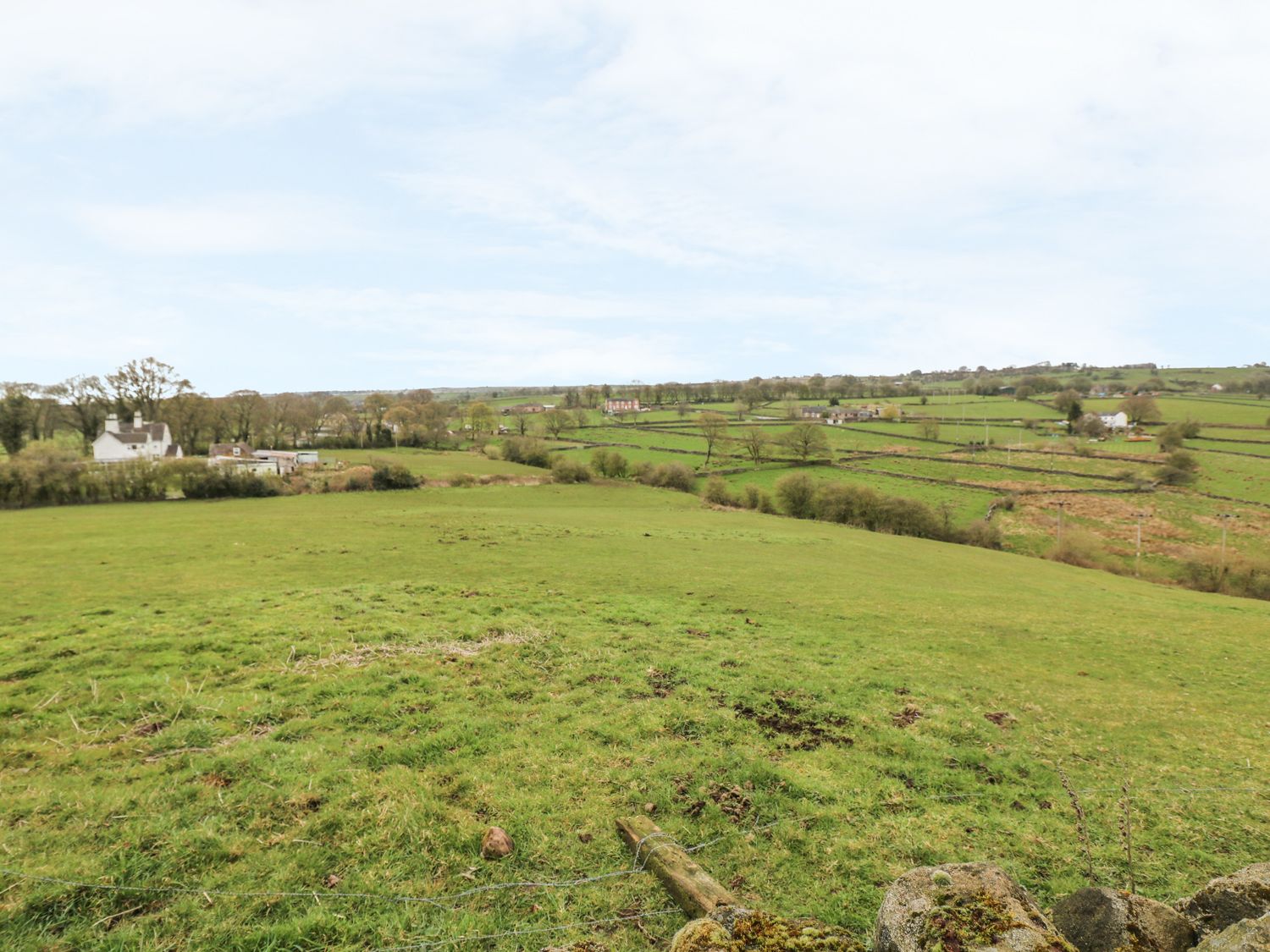 A rural landscape with green fields trees and scattered houses at The Old Sty in Alton