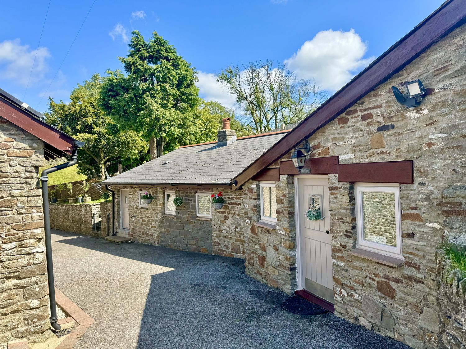 A stone building with a door and windows at Caner Bach Lodge in Blackmill