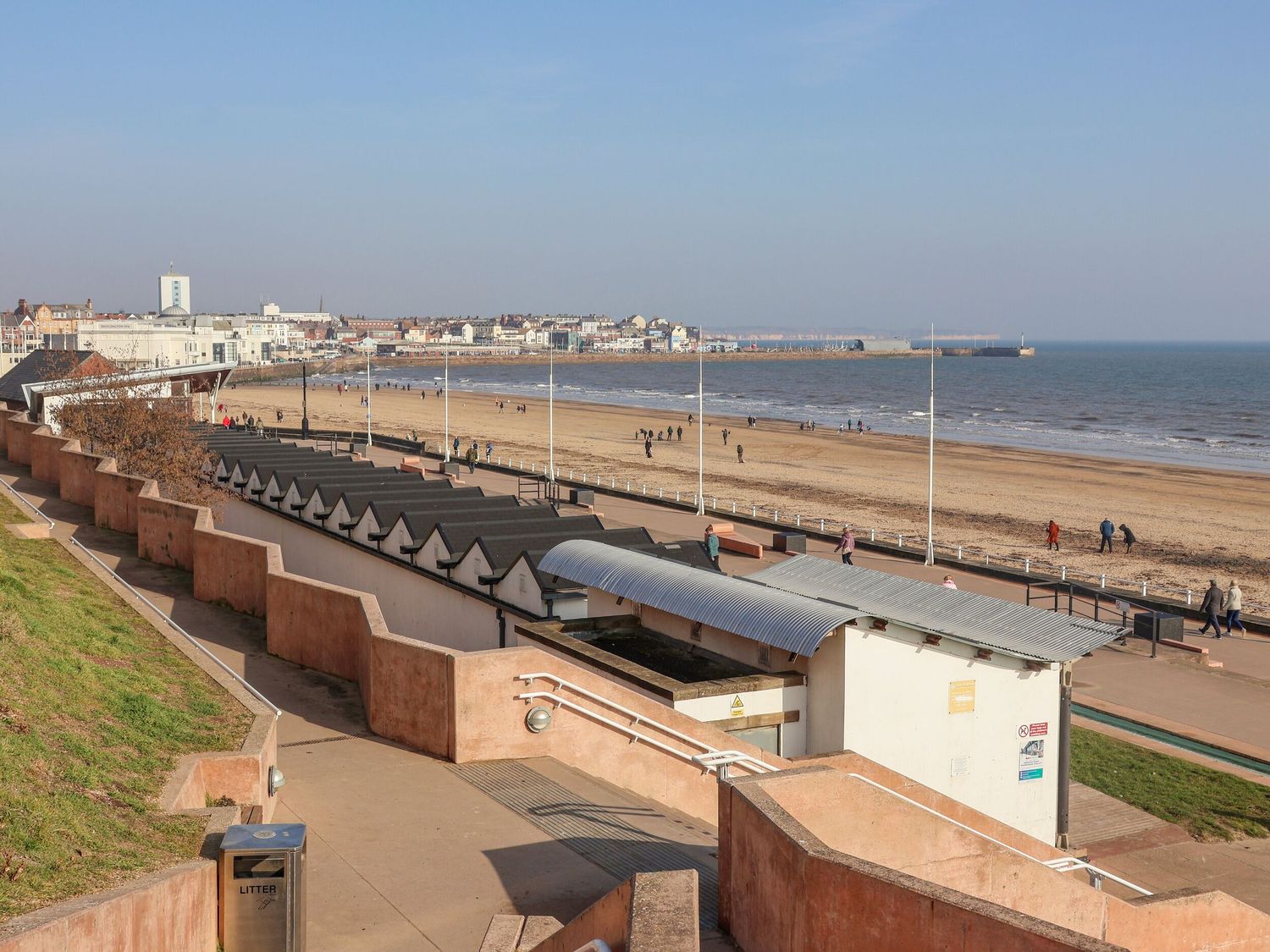 A beach with huts and people walking at Apt 2 @ Hunter's Quay in Bridlington