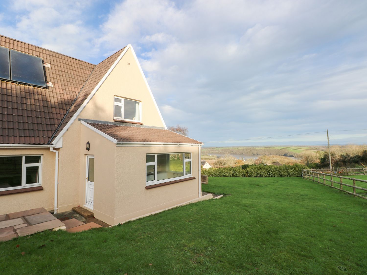 An exterior view of a house with a lawn at Cherry Trees in Haverfordwest