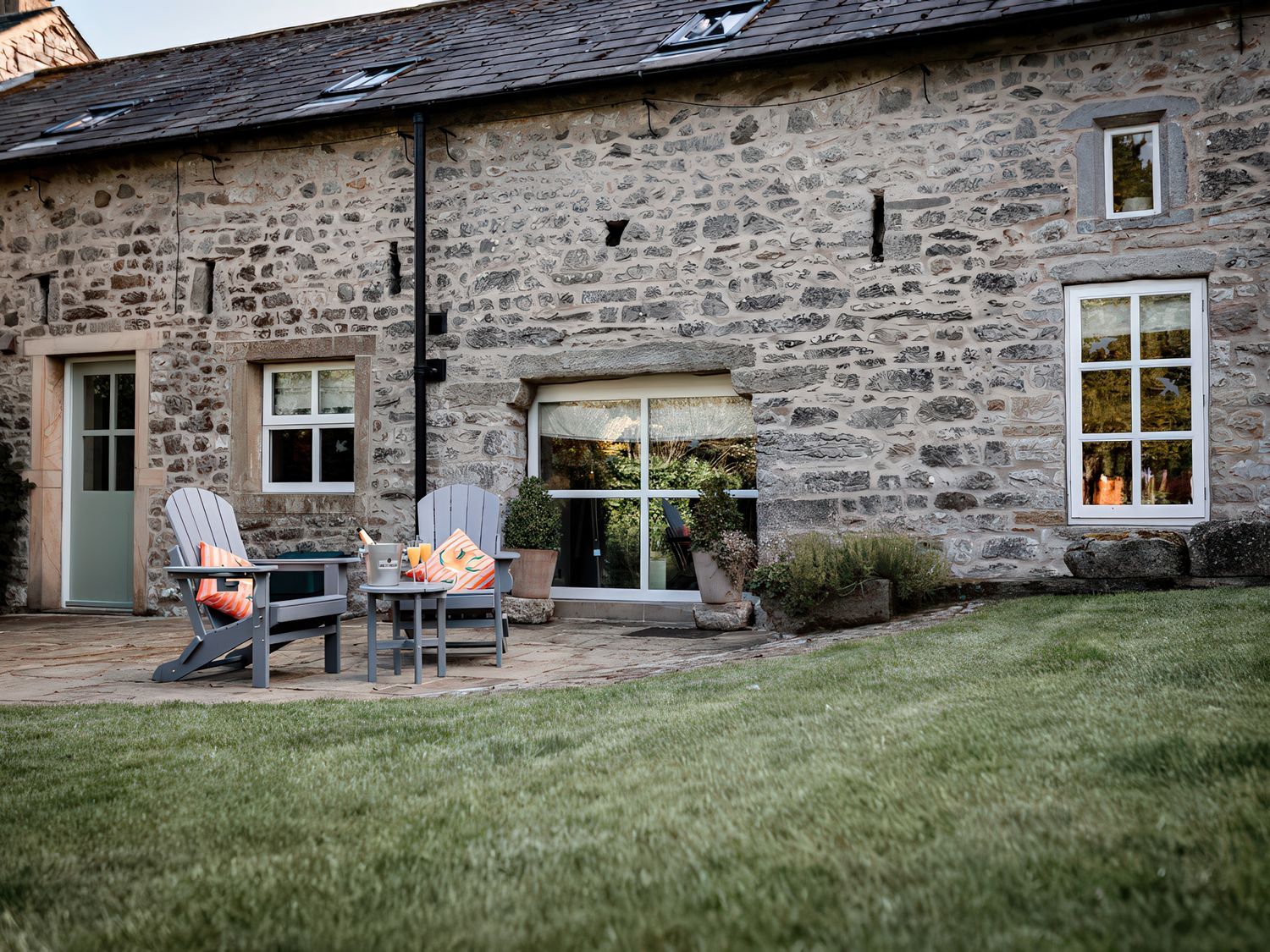 A patio area with chairs and a table at Carrholme Cottage Settle