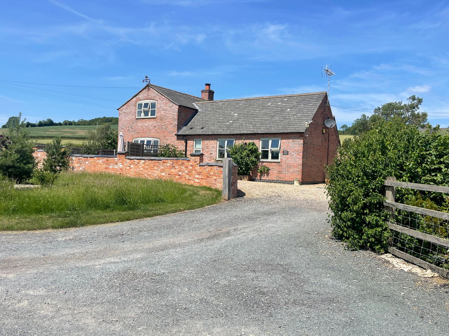 A house with a driveway and garden at Grooms Cottage in Uppingham