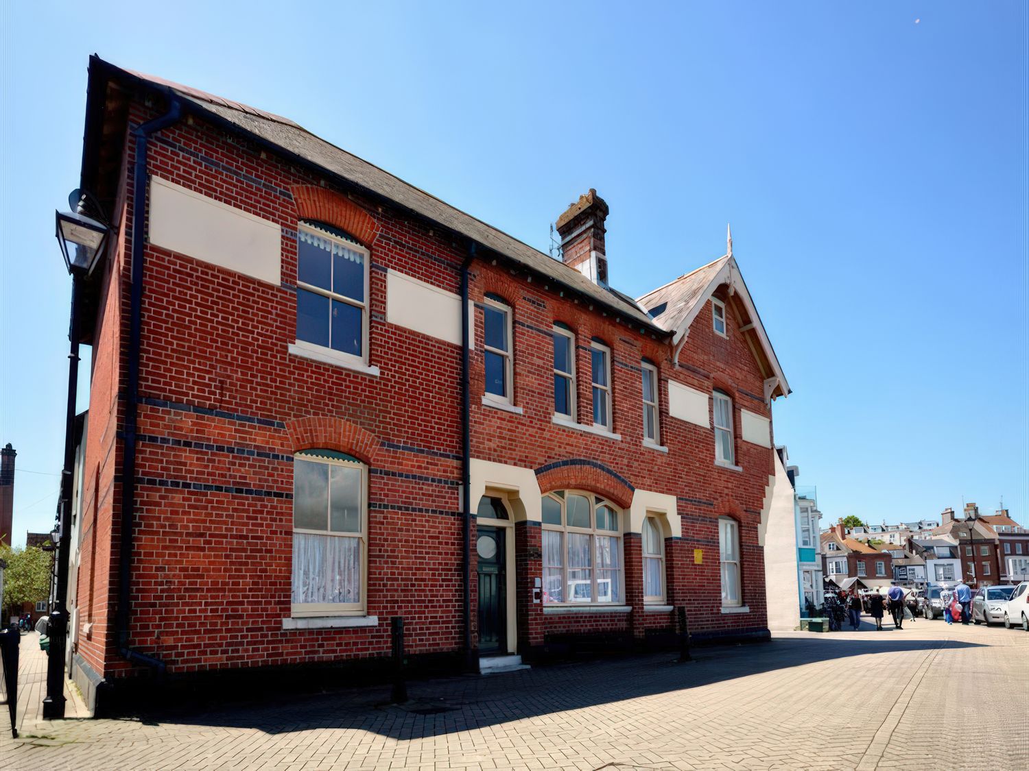 An outdoor view of a brick building with windows and a door at Mutiny House, Brewers Quay Harbour