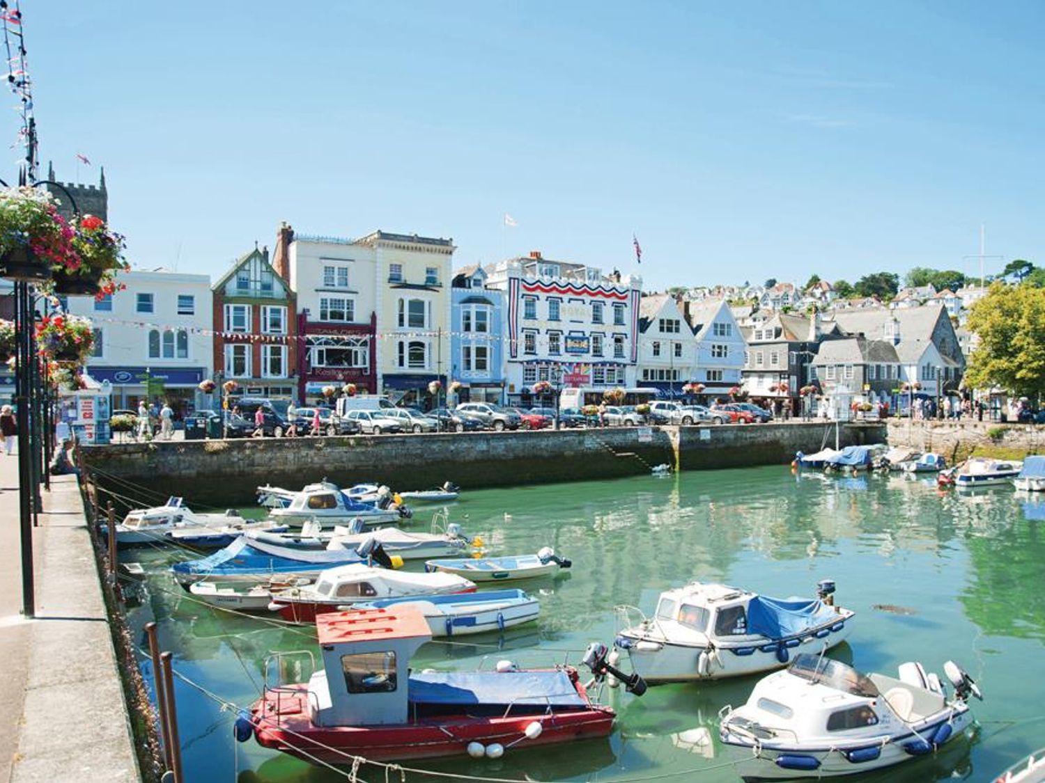 A harbor with boats docked in the water and buildings along the waterfront at Armada Cottage Dartmouth