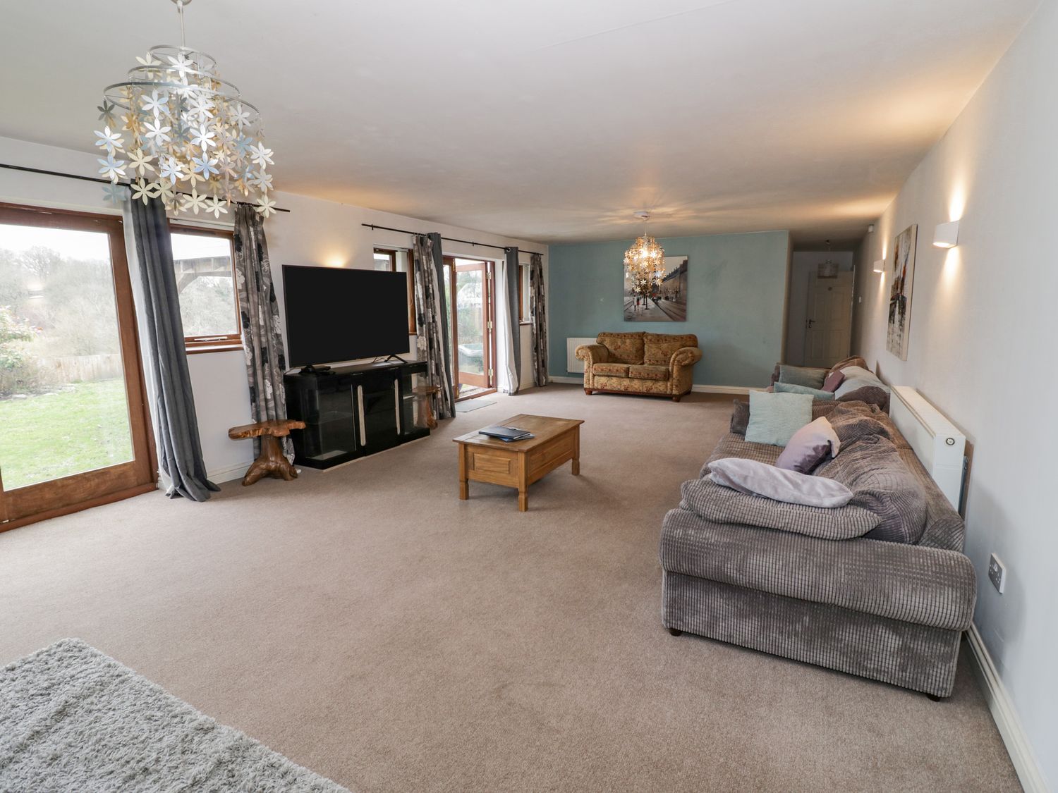 A living room with sofas a coffee table a television and glass doors at Shatterford Lakes in Shatterford