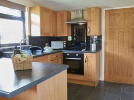A kitchen with wooden cabinets and appliances at Daffodil Lodge, Saltburn-by-the-Sea