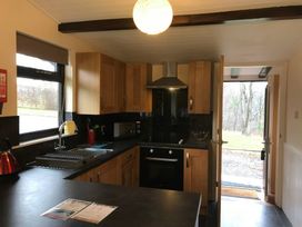 A kitchen with wooden cabinets and a sink at Daffodil Lodge Saltburn-by-the-Sea