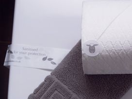 A towel and a paper towel with a sanitisation label at Daffodil Lodge in Saltburn-by-the-Sea