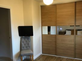 A bedroom with a chair and a TV at Daffodil Lodge in Saltburn-by-the-Sea
