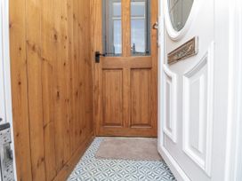 A hallway showing a wooden door and decorative floor tiles at Chapel Cottage in Filey