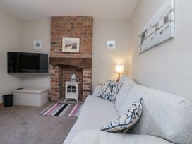 A living room with a sofa and television at Chapel Cottage in Filey